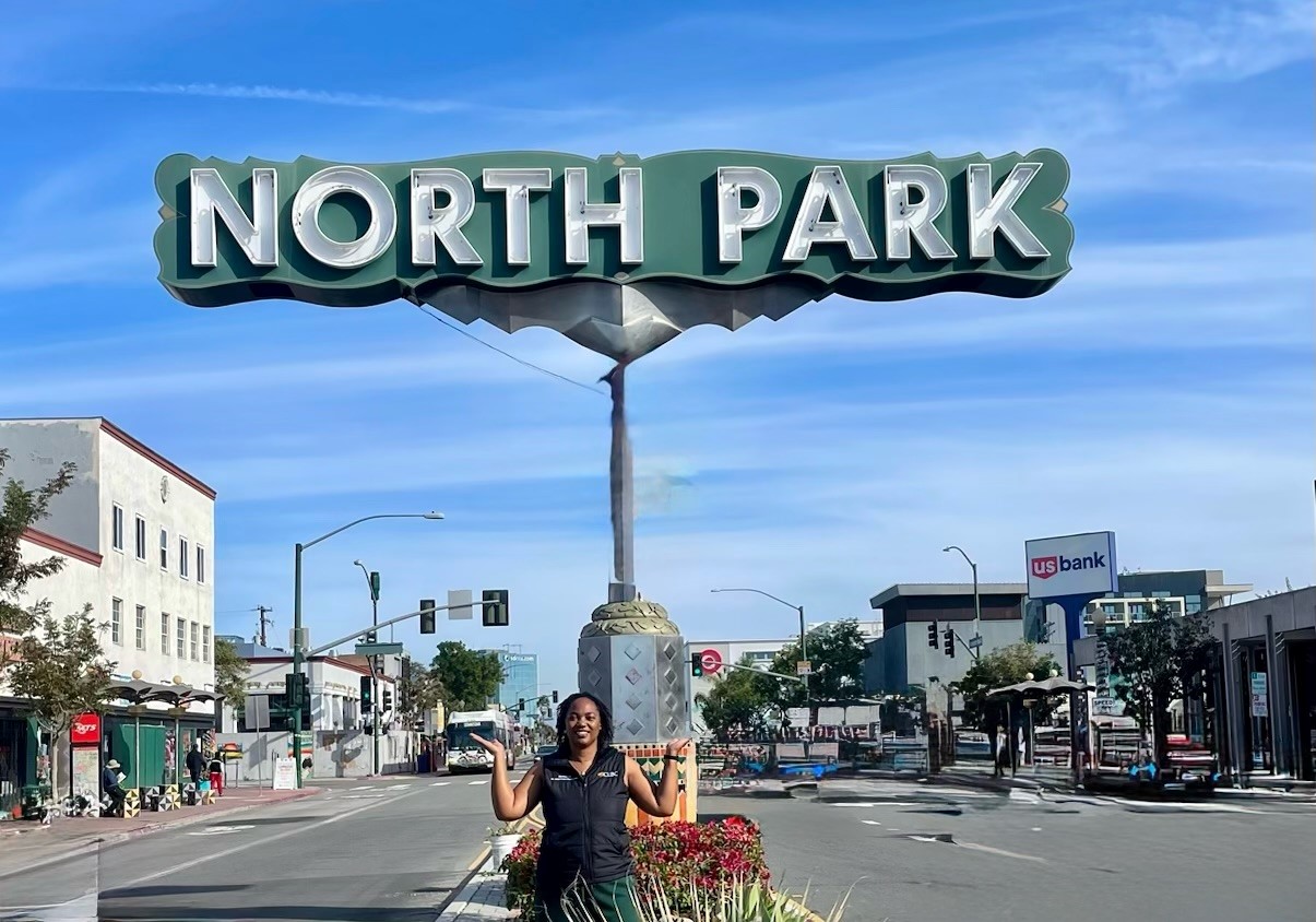 Senator Weber Pierson stands in front of a sign for the North Park community of her district. 